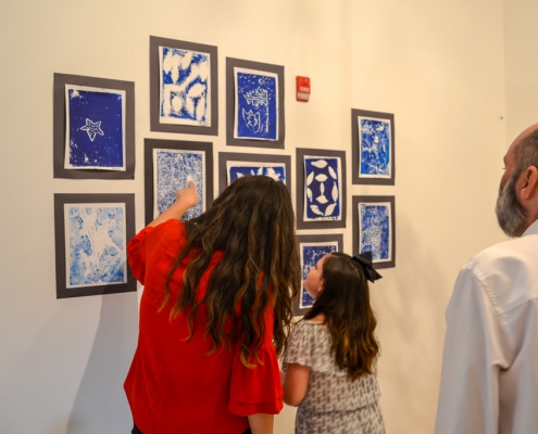 Education Director Pamela Cevallos and a West Wortham student go over the childrens' art together.