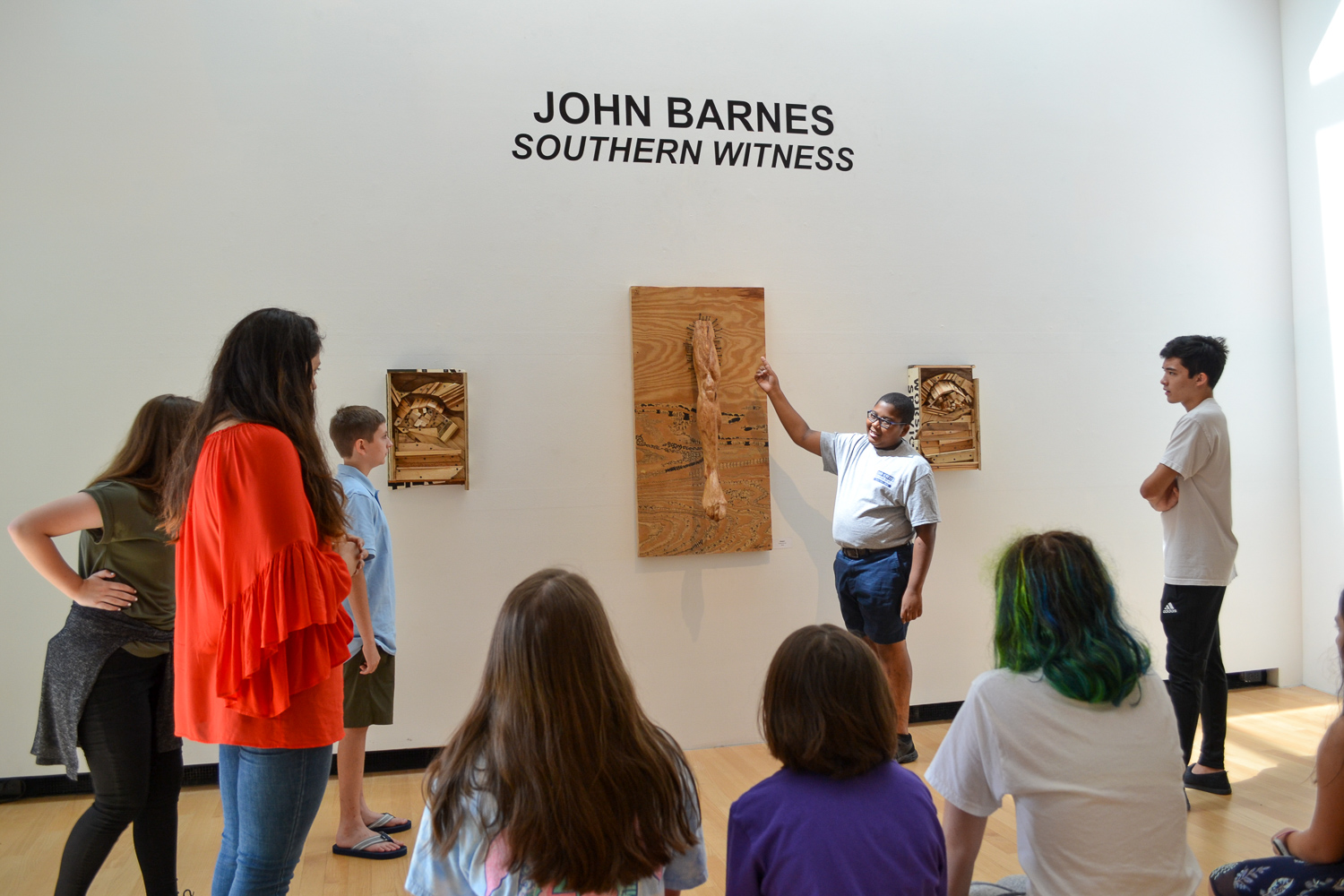 Summer campers discuss the art of John Barnes in the galleries at OOMA